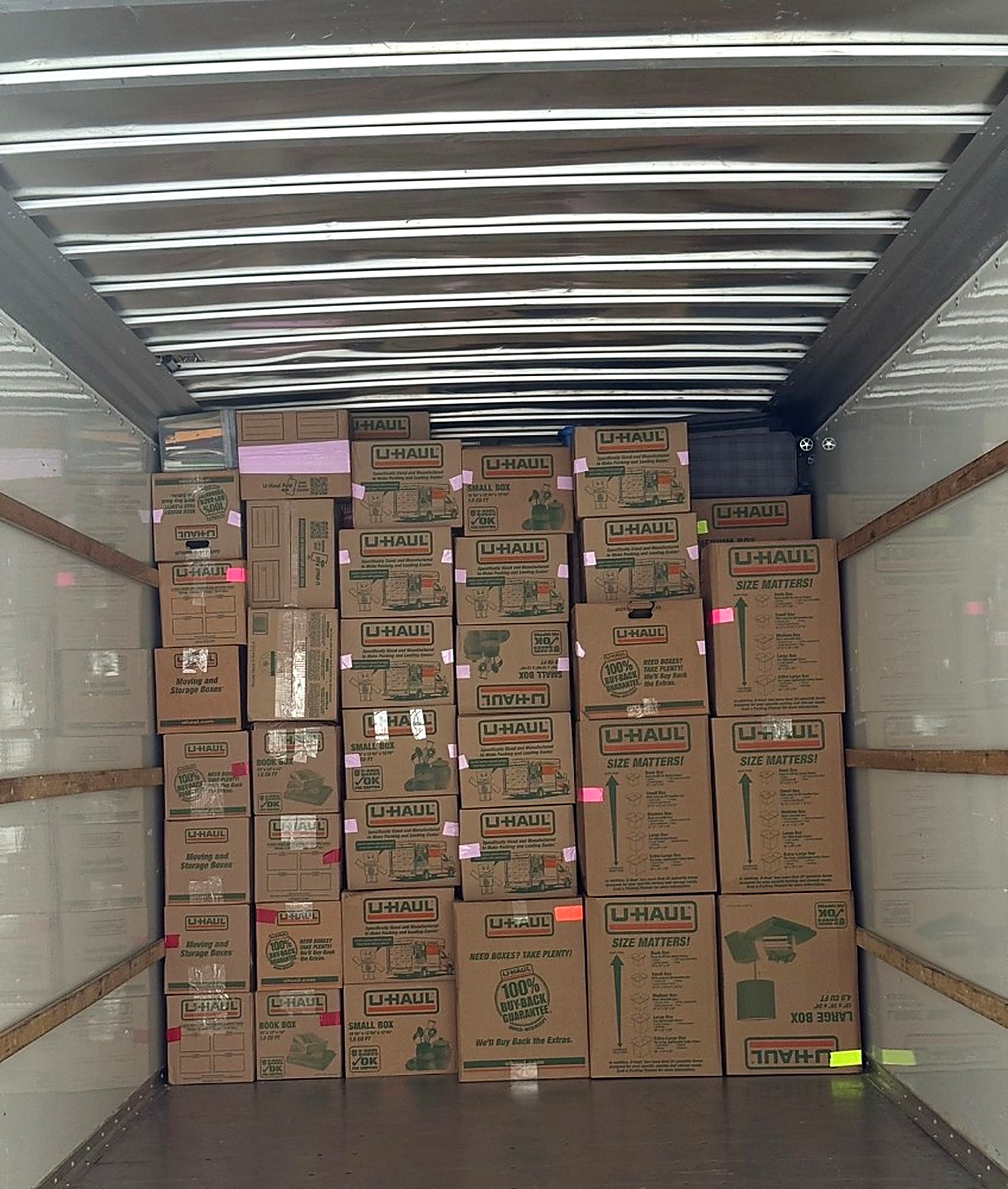 Moving truck packed floor to ceiling with neatly stacked, labeled boxes
